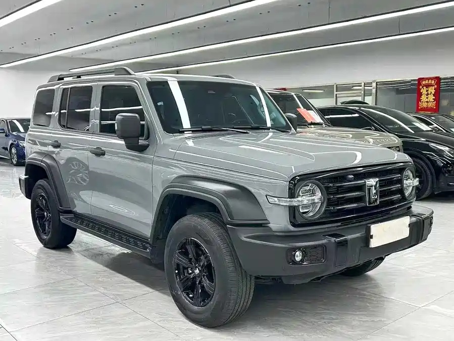 Representative grey-green 2024 GWM Tank 300 front three-quarter view in a vehicle showroom